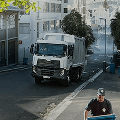 Vullisvragmotor op stadsstraat, werker rol blou asblik