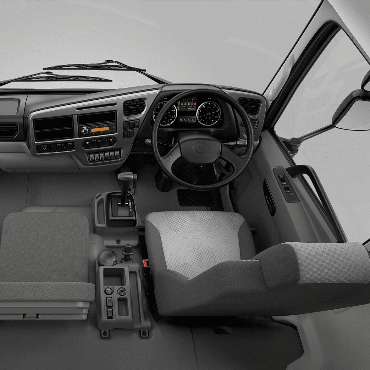 Truck cabin interior with steering wheel, dashboard, and two gray seats