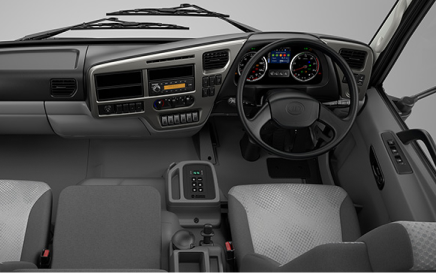 Gray truck cabin interior with three seats, dashboard, and steering wheel on the right.