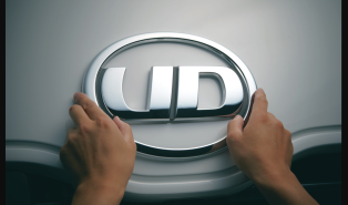 車のUDロゴを両手で触れている様子