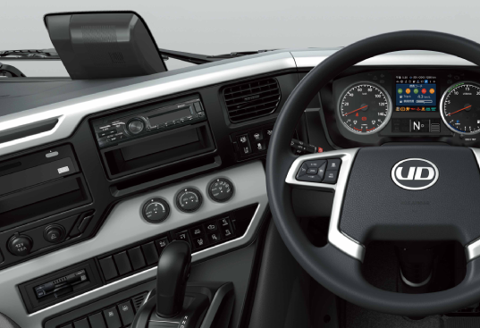 UDトラックの運転席、黒とシルバーの内装とデジタルメーター。