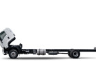 Truck chassis with white cab tilted forward on a white background.